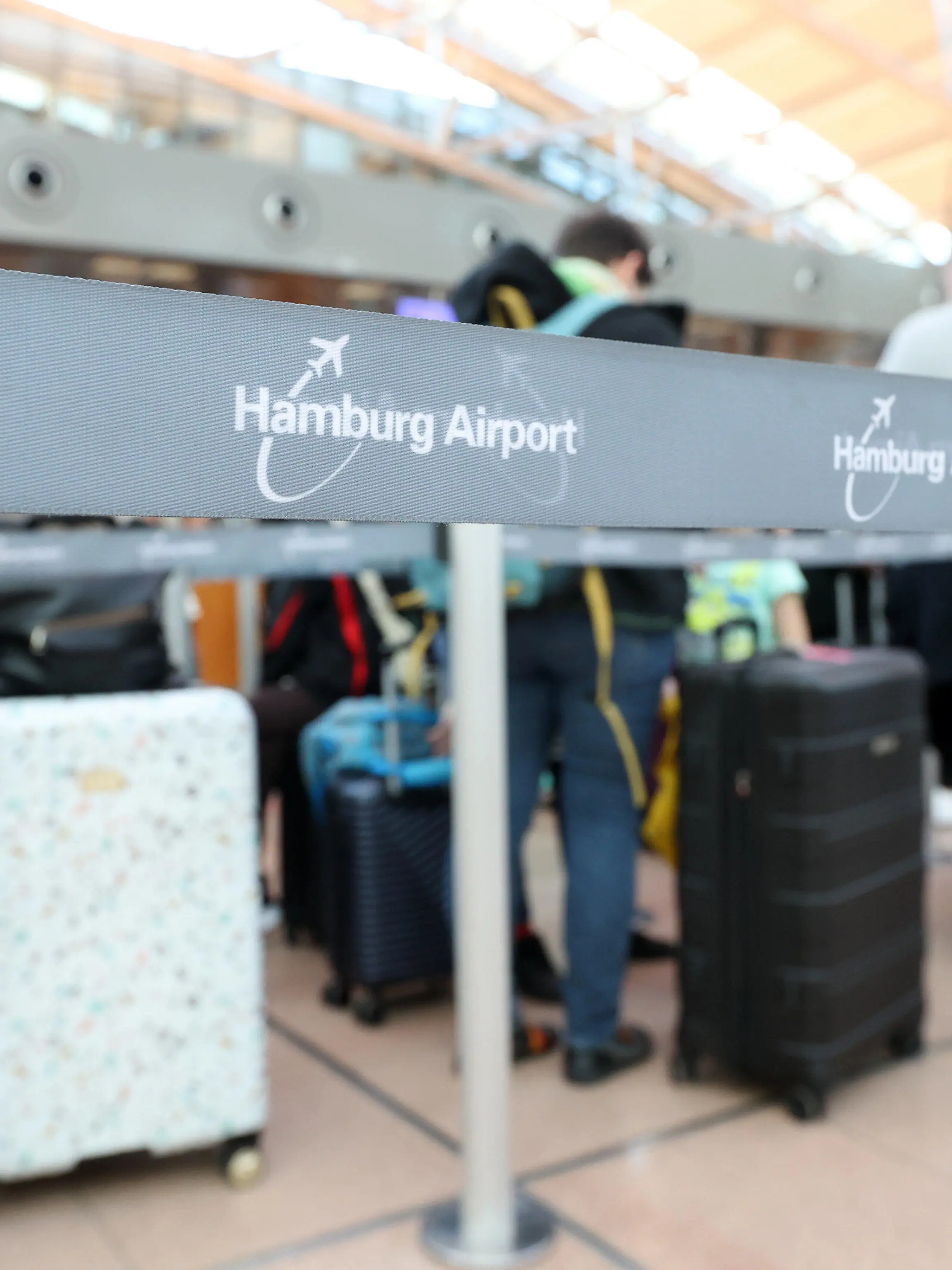 26.03.2023, Hamburg: Reisende stehen im Terminal 1 im Flughafen Hamburg an einem Check-In-Schalter an. Die Gewerkschaft Verdi und die Eisenbahn- und Verkehrsgewerkschaft (EVG) haben für Montag zu einem bundesweiten Warnstreik im Verkehr aufgerufen Foto: Bodo Marks/dpa +++ dpa-Bildfunk +++