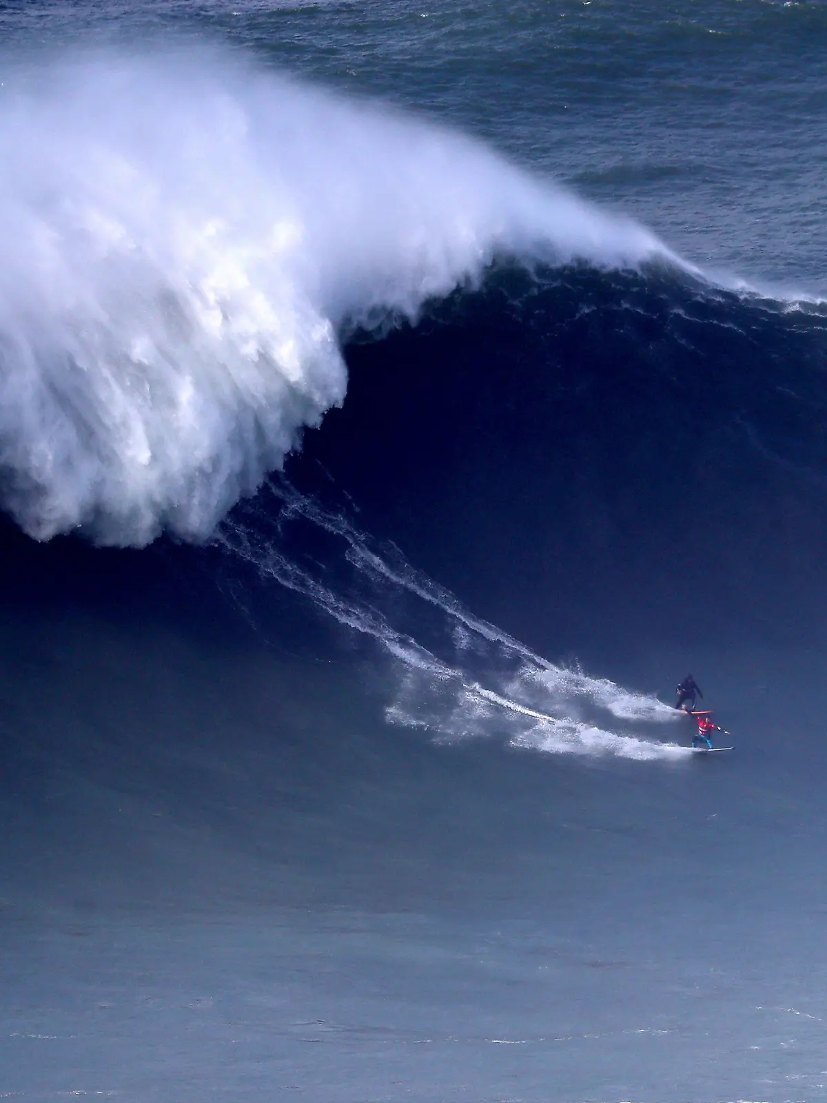 dpatopbilder - 11.02.2020, Portugal, Nazare: Andrew Cotton aus Großbritannien (unten) und Hugo Vau aus Portugal treten bei einem Surf-Wettbewerb gegeneinander an. Foto: Pedro Fiuza/XinHua/dpa +++ dpa-Bildfunk +++