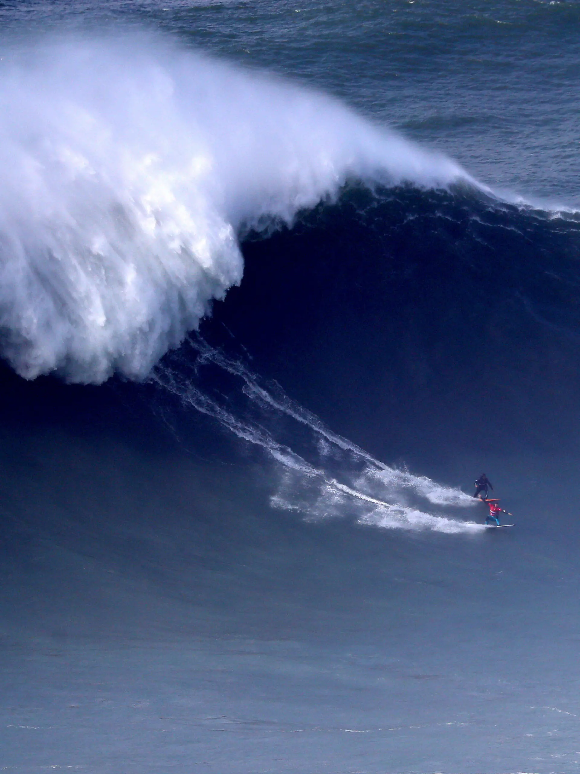 dpatopbilder - 11.02.2020, Portugal, Nazare: Andrew Cotton aus Großbritannien (unten) und Hugo Vau aus Portugal treten bei einem Surf-Wettbewerb gegeneinander an. Foto: Pedro Fiuza/XinHua/dpa +++ dpa-Bildfunk +++