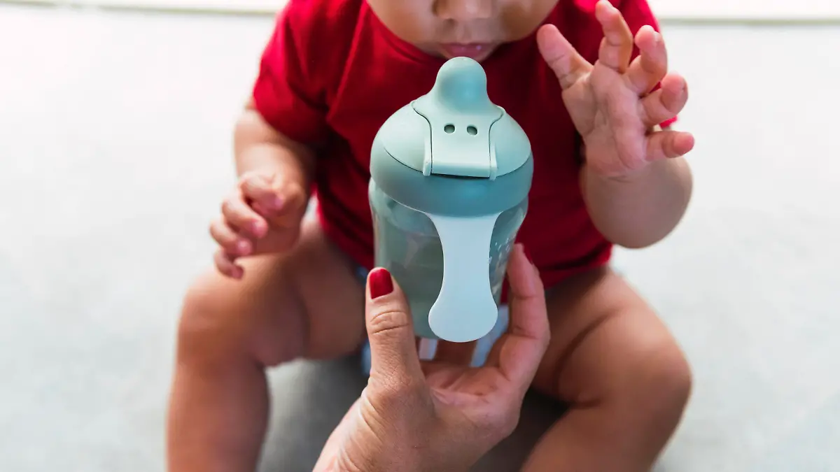 Mother giving baby bottle to son sitting at home model released, Symbolfoto property released, PNAF04524