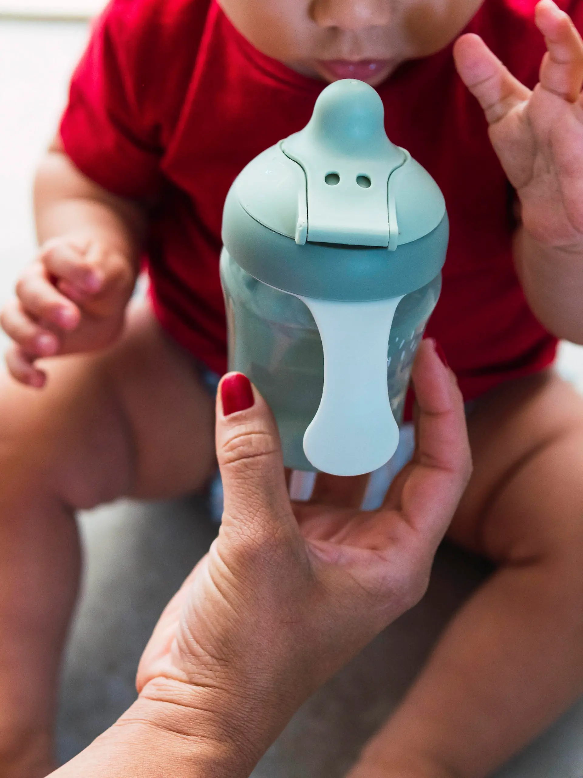 Mother giving baby bottle to son sitting at home model released, Symbolfoto property released, PNAF04524
