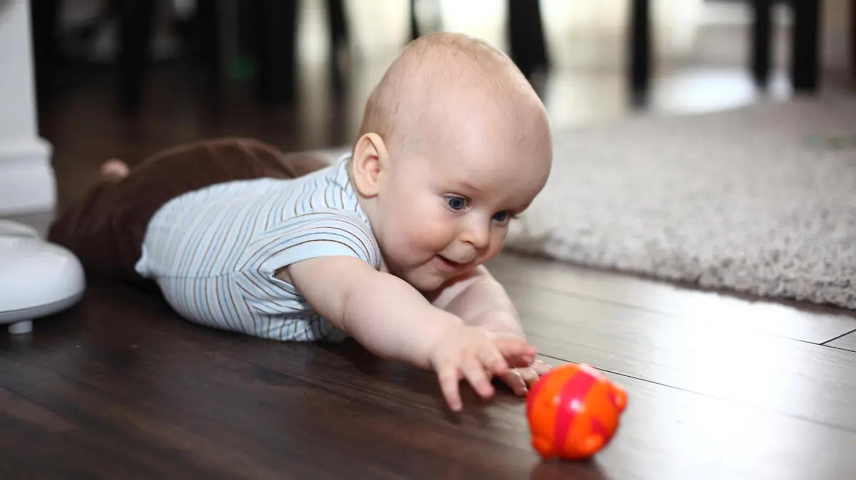 Baby greift nach einem Spielzeug