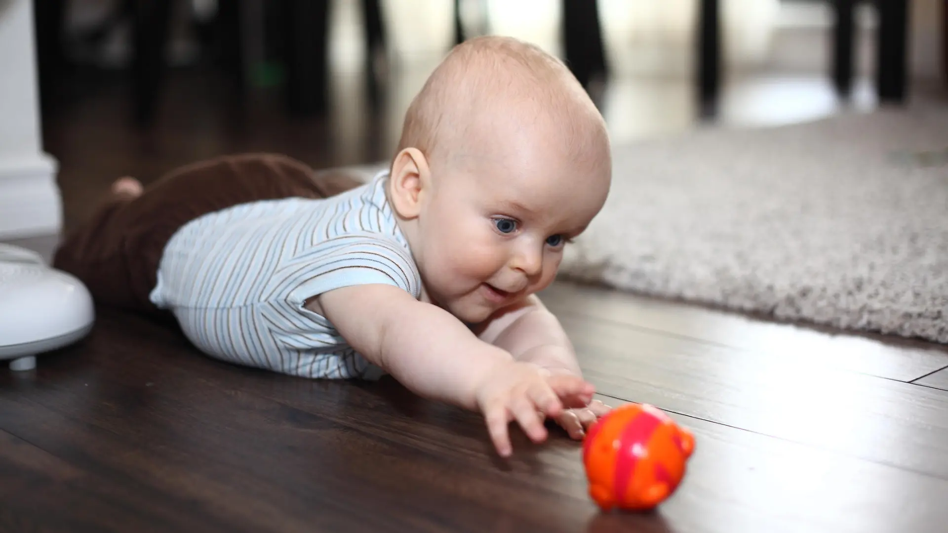 Baby greift nach einem Spielzeug