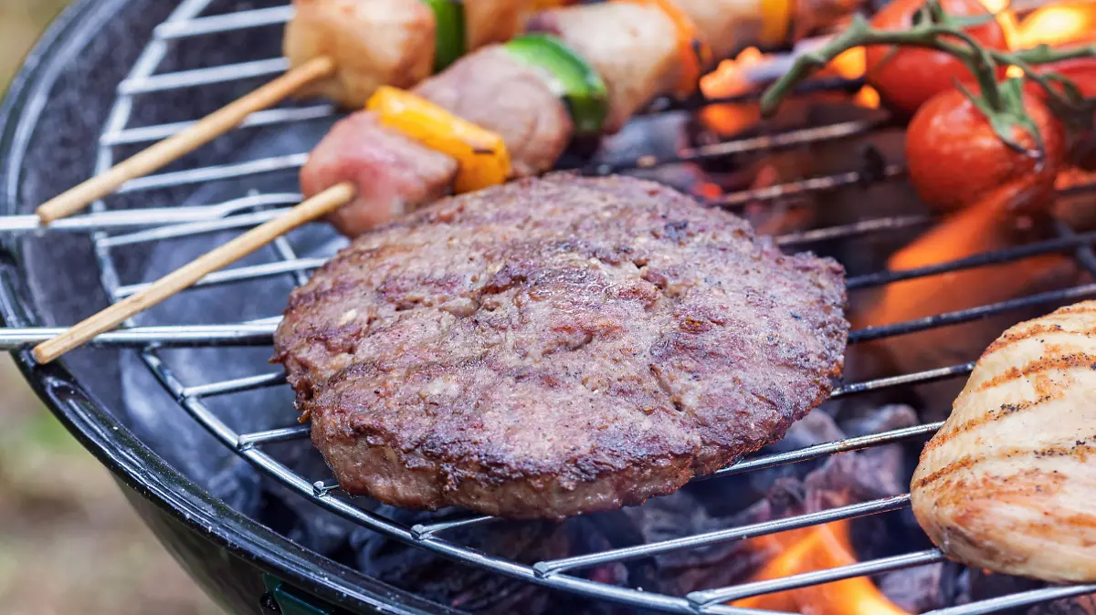 preparing various meat and vegetables on barbecue in the nature
