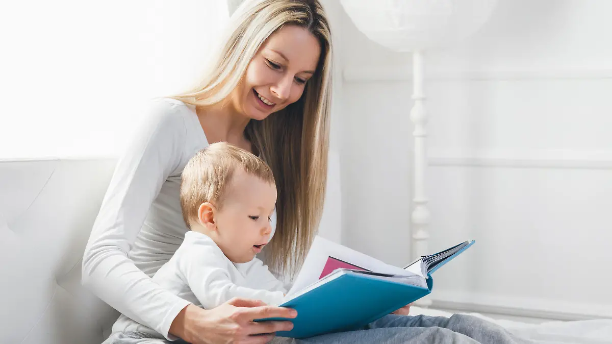 Mutter liest mit Baby aus Bilderbuch