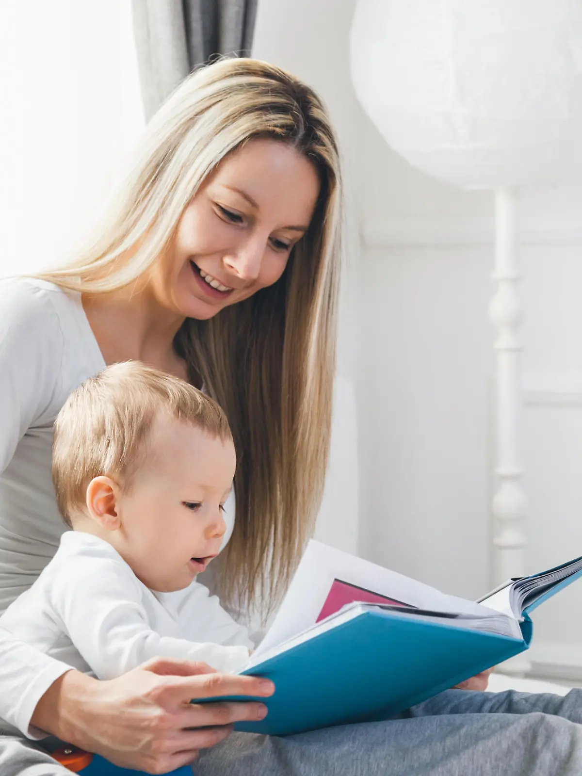 Mutter liest mit Baby aus Bilderbuch