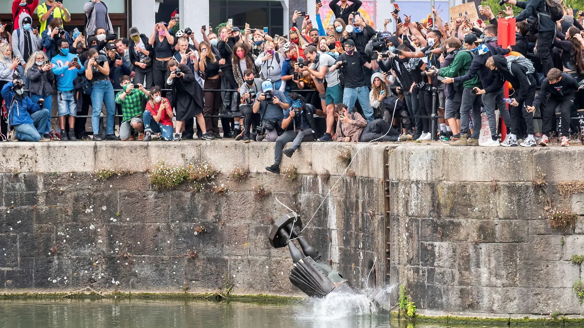 FILE PHOTO: The statue of 17th century slave trader Edward Colston falls into the water after protesters pulled it down and pushed into the docks, during a protest against racial inequality in the aftermath of the death in Minneapolis police custody of George Floyd, in Bristol, Britain, June 7, 2020. Picture taken June 7, 2020. Keir Gravil via REUTERS THIS IMAGE HAS BEEN SUPPLIED BY A THIRD PARTY. MANDATORY CREDIT. THIS IMAGE WAS PROCESSED BY REUTERS TO ENHANCE QUALITY, AN UNPROCESSED VERSION HAS BEEN PROVIDED SEPARATELY. - RC2A6H918CNF/File Photo