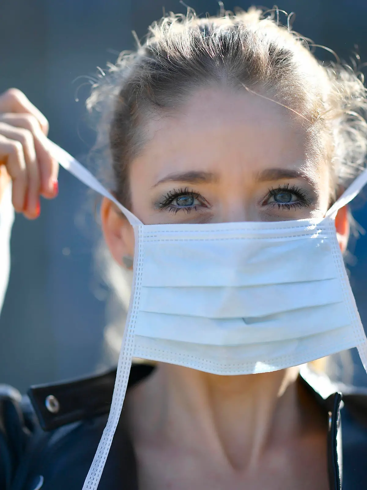 Frau legt Mundschutzmaske an, Portrait, Corona-Krise, Stuttgart, Baden-Württemberg, Deutschland Coronavirus *** Woman putting on face mask, portrait, corona crisis, Stuttgart, Baden Württemberg, Germany Coronavirus 