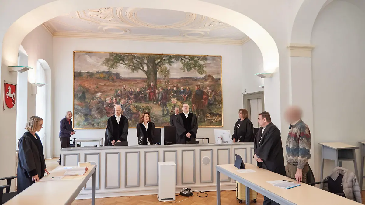 23.03.2023, Niedersachsen, Lüneburg: Der Angeklagte (r), sein Verteidiger Markus Bauer (2.v.r.) sowie die Richter, Schöffen und weitere Anwesende stehen im Landgericht Lüneburg vor Beginn des Prozesses im Gerichtssaal. Dem Angeklagten wird besonders schwerer sexueller Missbrauch vorgeworfen. Der inzwischen 74 Jahre alte Mann soll als Schwimmtrainer und Betreuer von Ferienfreizeiten in 84 Fällen Kinder zwischen acht und 13 Jahren missbraucht haben. Foto: Georg Wendt/dpa +++ dpa-Bildfunk +++