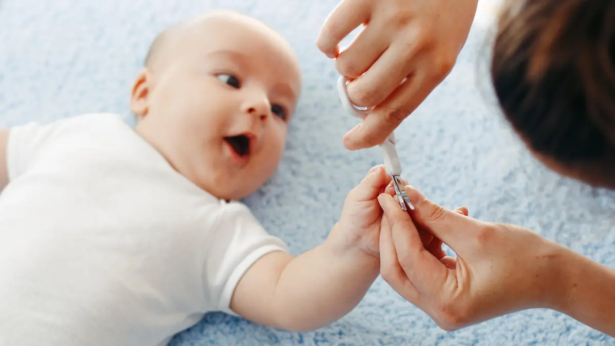 Mutter schneidet Baby die Nägel