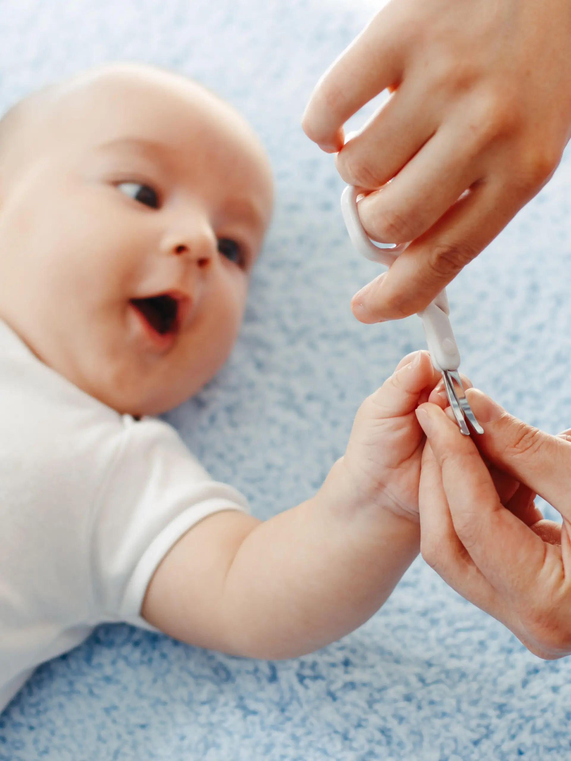 Mutter schneidet Baby die Nägel