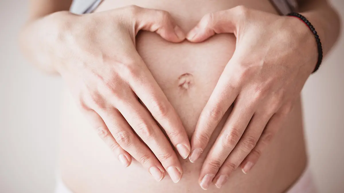 Mutter macht Herz über dem Bauch
