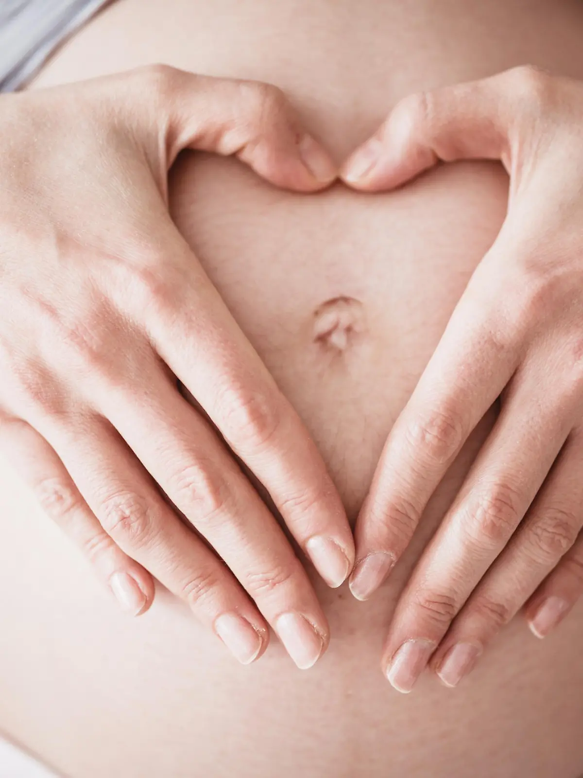Mutter macht Herz über dem Bauch