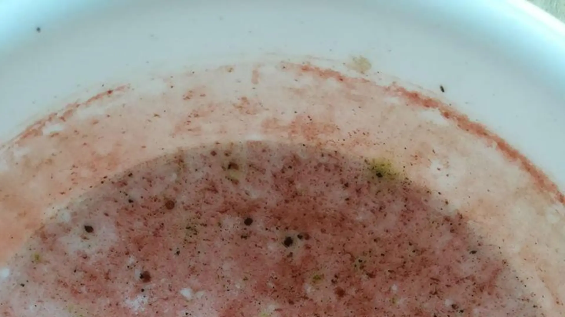 In einer Trinkschale für Vögel hat sich ein roter Belag gebildet.