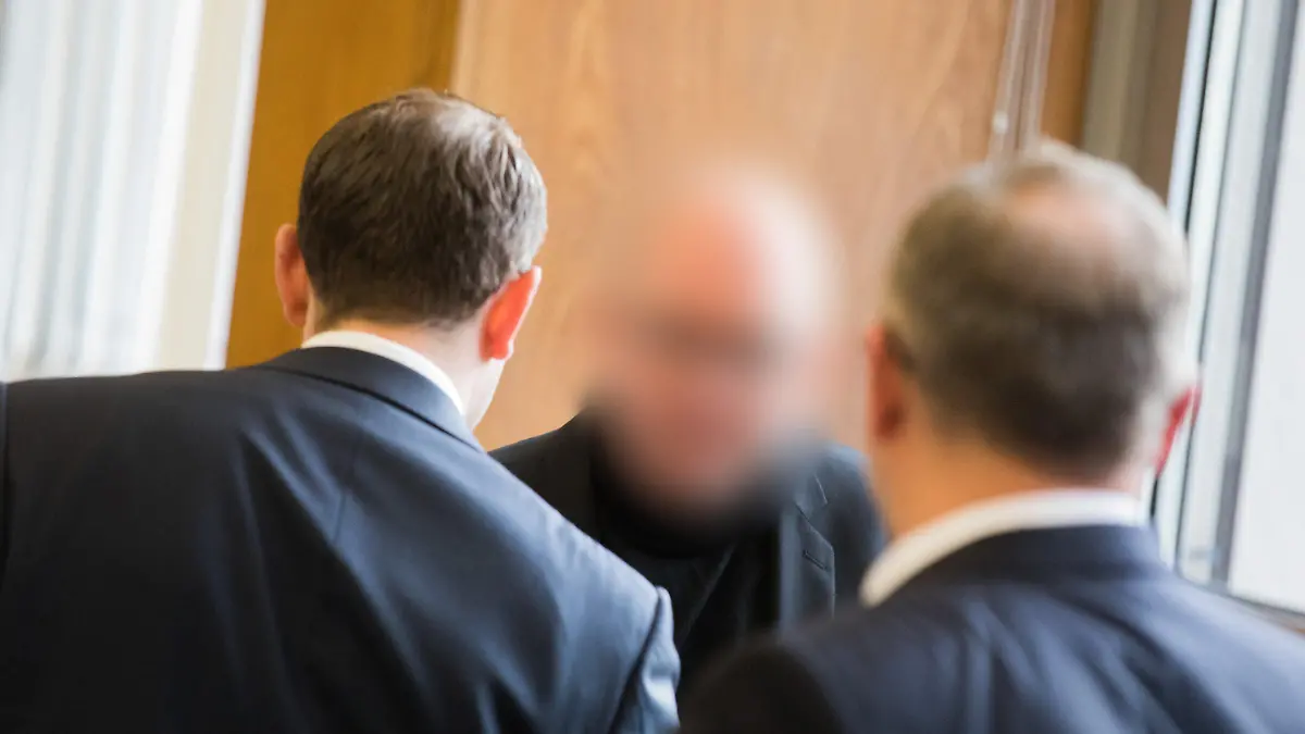 Der Angeklagte (M) steht am 13.11.2017 im Landgericht in Essen (Nordrhein-Westfalen) zwischen seinen Anwälten. Der 47 Jahre alte Apotheker aus Bottrop soll seit 2012 fast 62 000 Krebsmedikamente gepanscht haben. Durch betrügerische Abrechnungen soll gesetzlichen Krankenkassen ein Schaden von rund 56 Millionen Euro entstanden sein. (ACHTUNG: Der Angeklagte wurde aus persönlichkeitsrechtlichen Gründen unkenntlich gemacht) Foto: Rolf Vennenbernd/dpa +++(c) dpa - Bildfunk+++