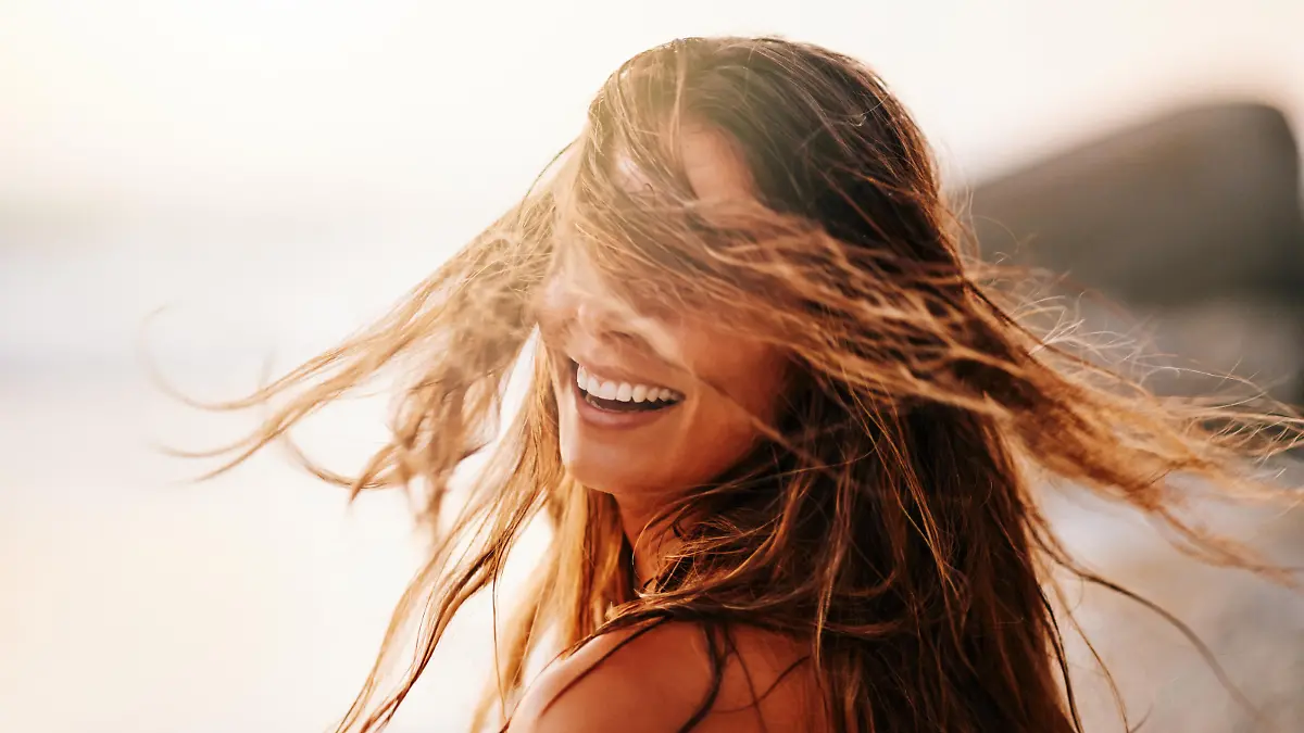 Shot of a beautiful and carefree young woman enjoying a day at the beach