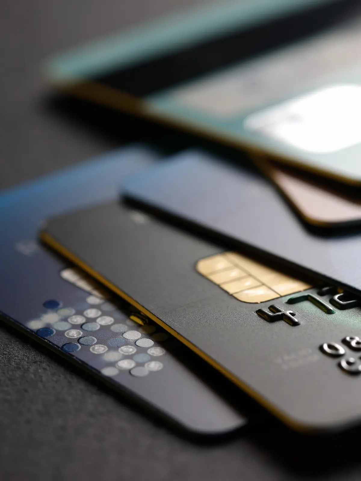 stack of multicolored credit cards on black background