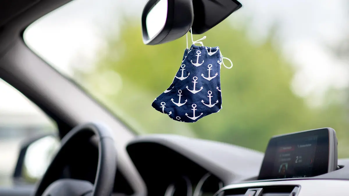ARCHIV - 02.05.2020, Niedersachsen, Oldenburg: Eine blaue Stoffmaske mit Anker-Motiv hängt an einem Rückspiegel in einem Auto. Das Coronavirus ist 2020 das Gesprächsthema schlechthin, auch wenn sich manche Familien und Freundeskreise schwören, das Thema bei Treffen außen vor zu lassen. (zu dpa «Wenn Corona vorbei ist...» - das Virus als Gesprächsthema") Foto: Hauke-Christian Dittrich/dpa +++ dpa-Bildfunk +++