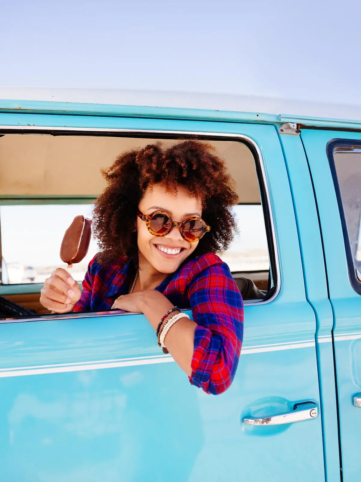 Frau isst Eis am Steuer ihres Autos
