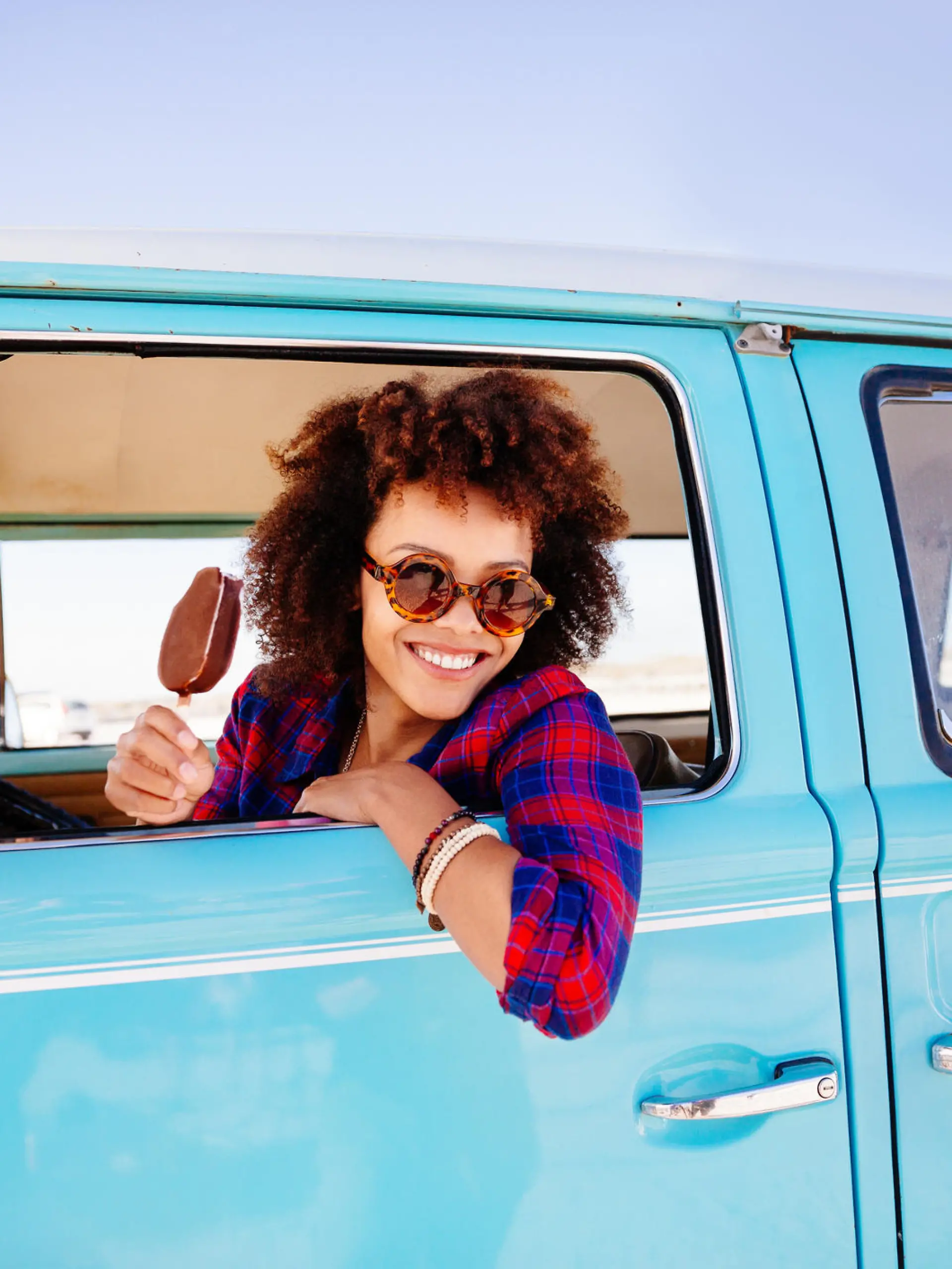 Frau isst Eis am Steuer ihres Autos