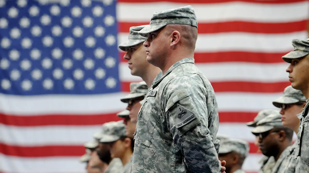 ARCHIV - 10.12.2008, Hessen, Wiesbaden: US-Soldaten stehen nach ihrer Ankunft auf der US-Airbase in Wiesbaden-Erbenheim vor einer US-Flagge. Der Abzug von rund 9500 US-Soldaten aus Deutschland ist beschlossene Sache. (zu dpa: «US-Verteidigungsministerium: Truppenabzug aus Deutschland beschlossen») Foto: Frank May/dpa +++ dpa-Bildfunk +++