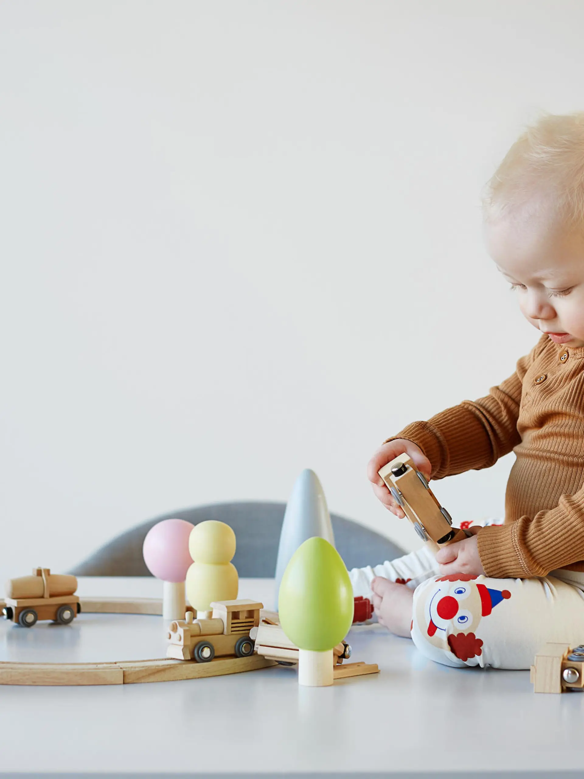 Baby spielt mit Holzeisenbahn