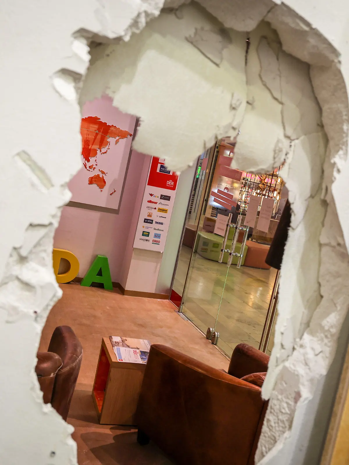 27.03.2023, Bremen: Ein Loch ist in der Wand des Geschäfts eines Schlüsseldienstes im Roland-Center Einkaufszentrum in Bremen-Huchting zu sehen. Am Wochenende hatten laut Polizei Einbrecher die Wände mehrerer Geschäfte aufgestemmt, um durch diese an die Vitrinen eines Juweliergeschäftes zu gelangen, aus denen sie Schmuckstücke von noch nicht beziffertem Wert entwendeten. Foto: Focke Strangmann/dpa +++ dpa-Bildfunk +++
