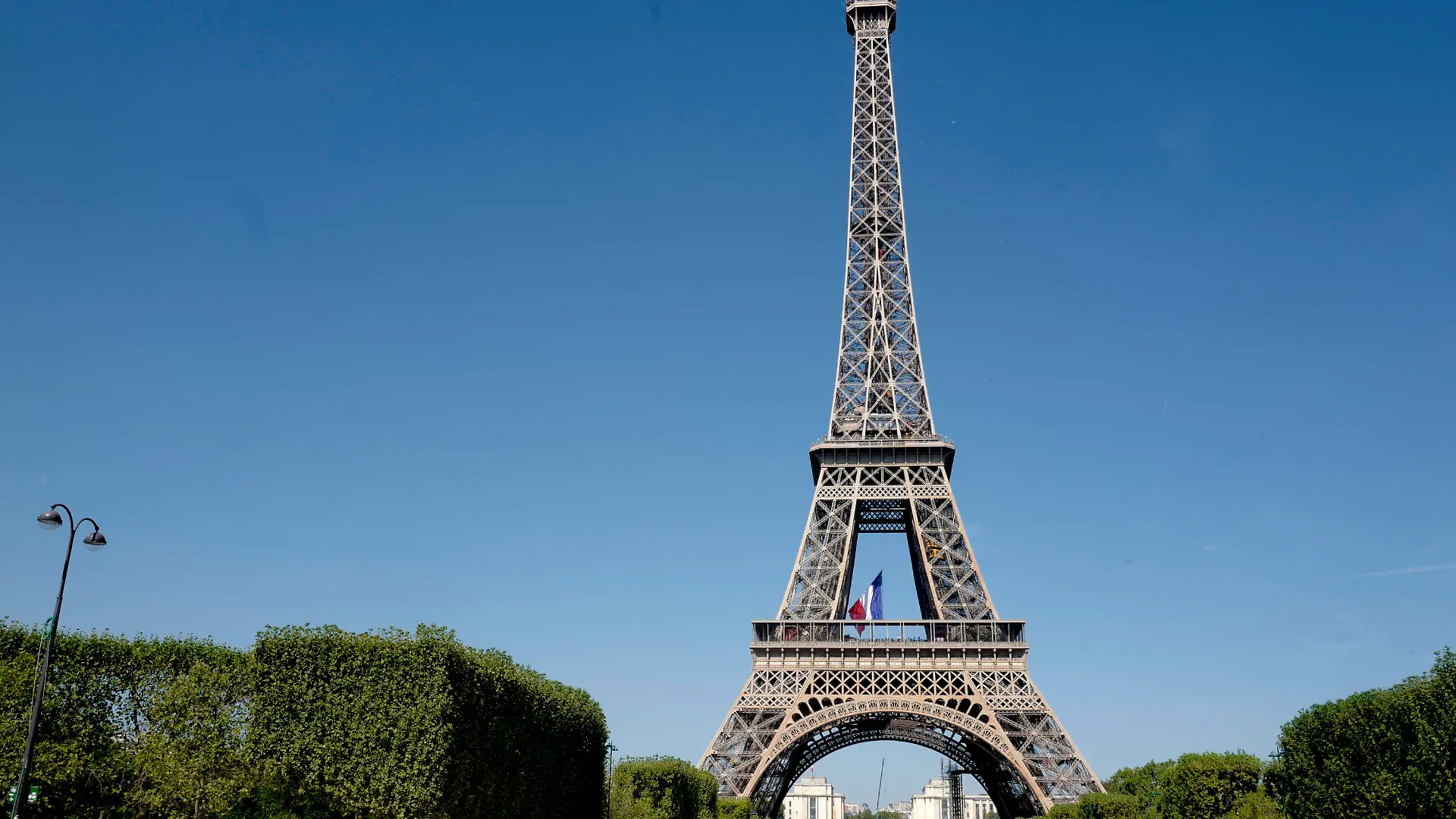ARCHIV - 25.08.2019, Frankreich, Paris: Die französische Nationalflagge hängt auf dem Eiffelturm - in Gedenken an den 75. Jahrestag der Befreiung von Paris durch die Alliierten im Zweiten Weltkrieg. (zu dpa-Korr "Vor Urlaubsstart: Wie sich Europas Reiseziele für Touristen wappnen") Foto: Michel Spingler/AP/dpa +++ dpa-Bildfunk +++