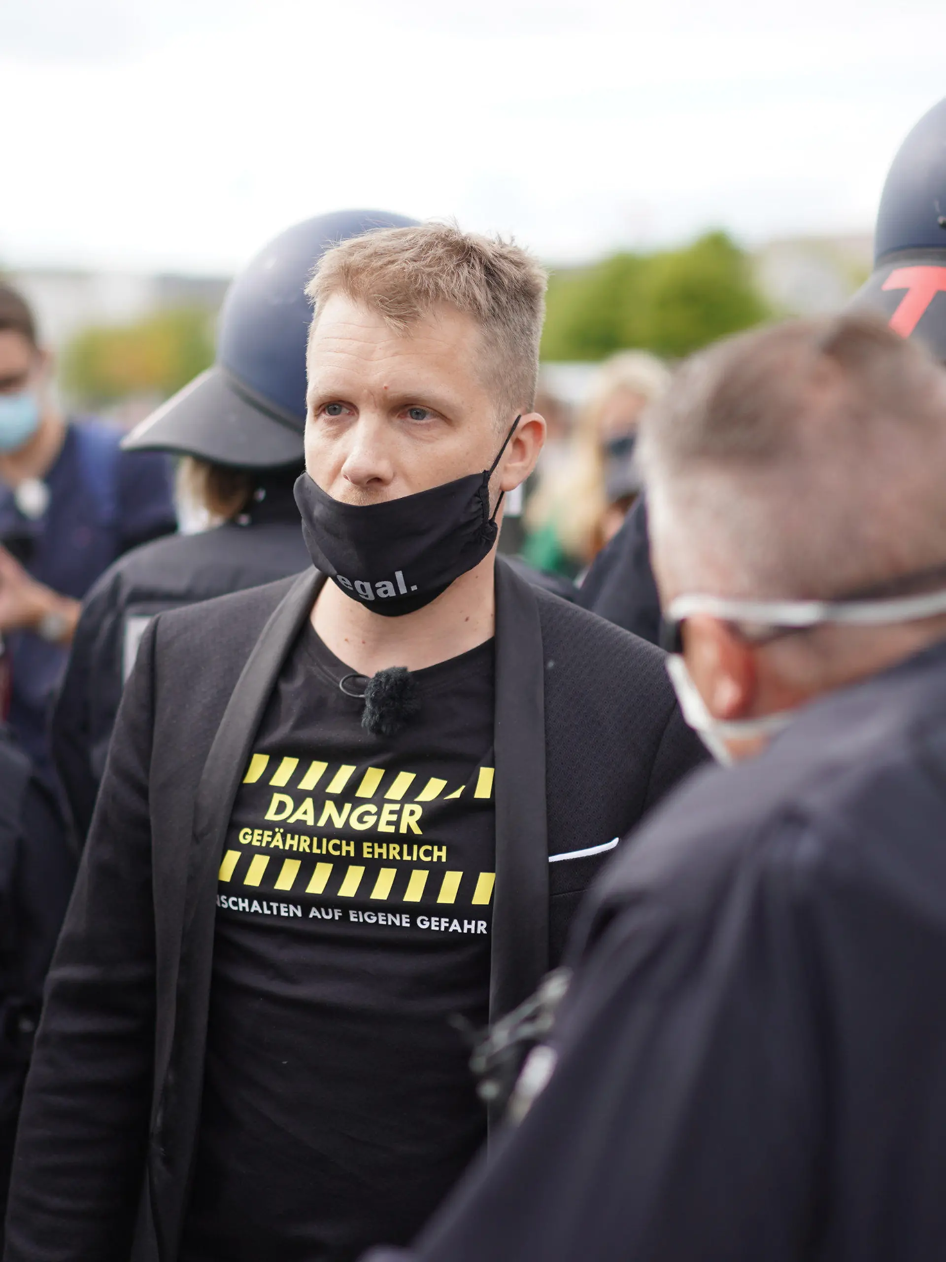 16.05.2020, Berlin: Comedian Oliver Pocher (M) im Gespräch mit einem Polizisten vor dem Reichstag. Vor dem Reichstagsgebäude hatten sich mehrere Hundert Menschen versammelt, um an einer Kundgebung des bekannten Kochs Hildmann teilzunehmen. Pocher, der mit Hildmann vor laufenden Kameras diskutiert hatte, wurde von der Polizei vom Gelände geleitet. Foto: Jörg Carstensen/dpa +++ dpa-Bildfunk +++