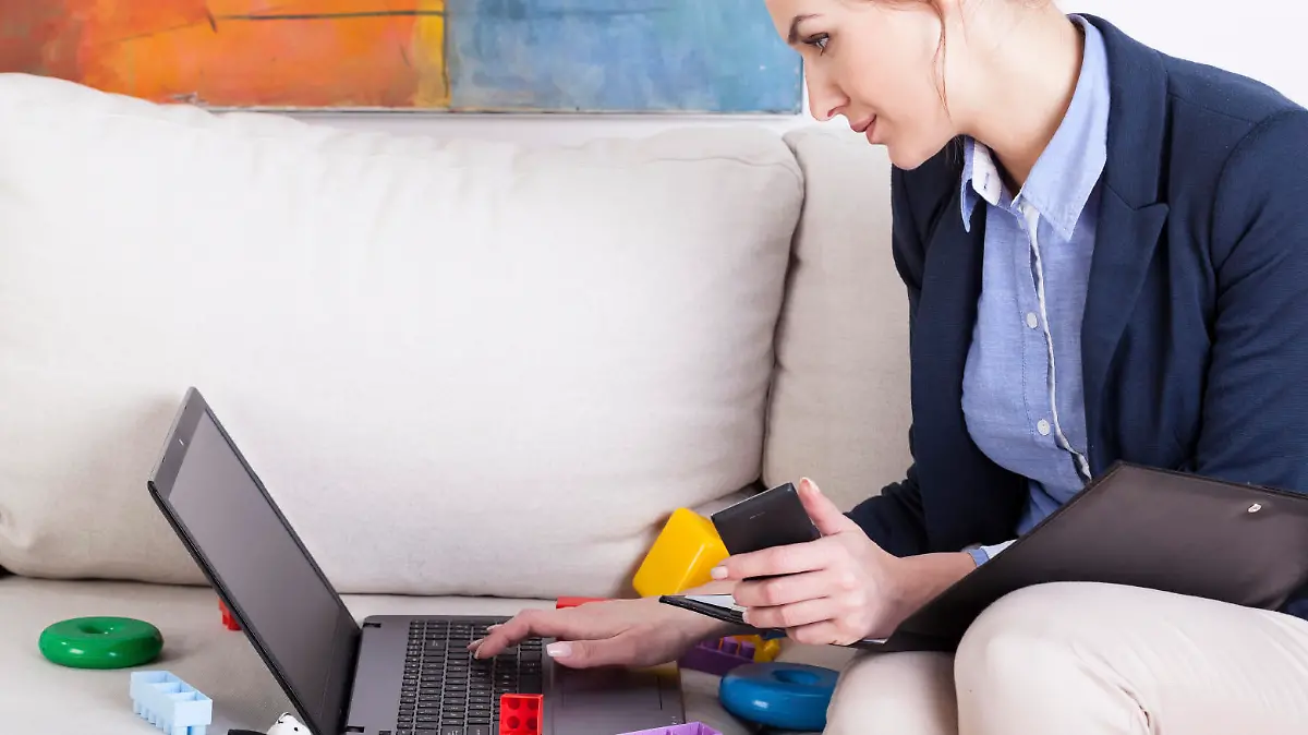 Young mother using laptop to work at home, horizontal