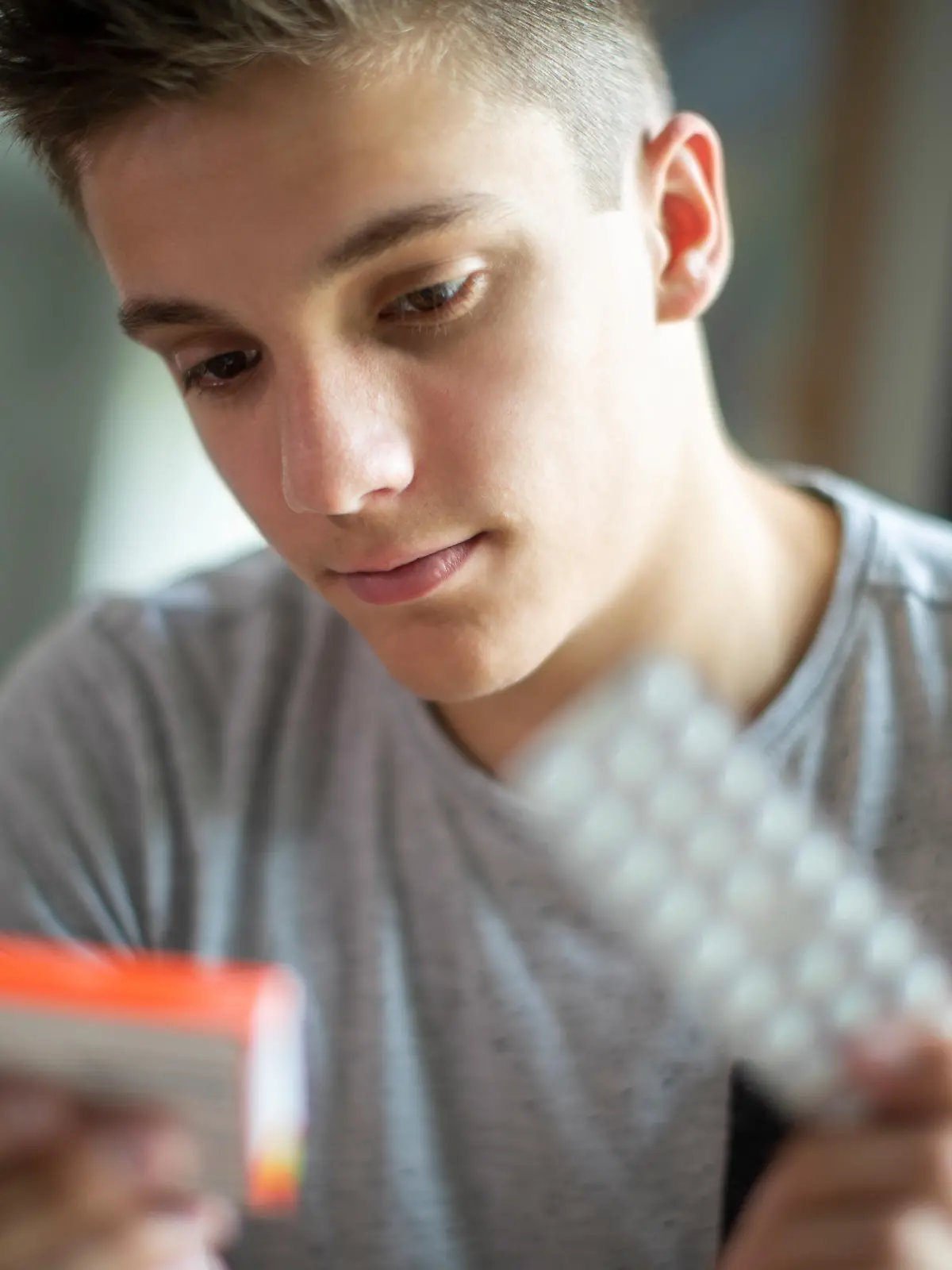 Teenage Boy With Mental Health Problems Taking Medication At Home