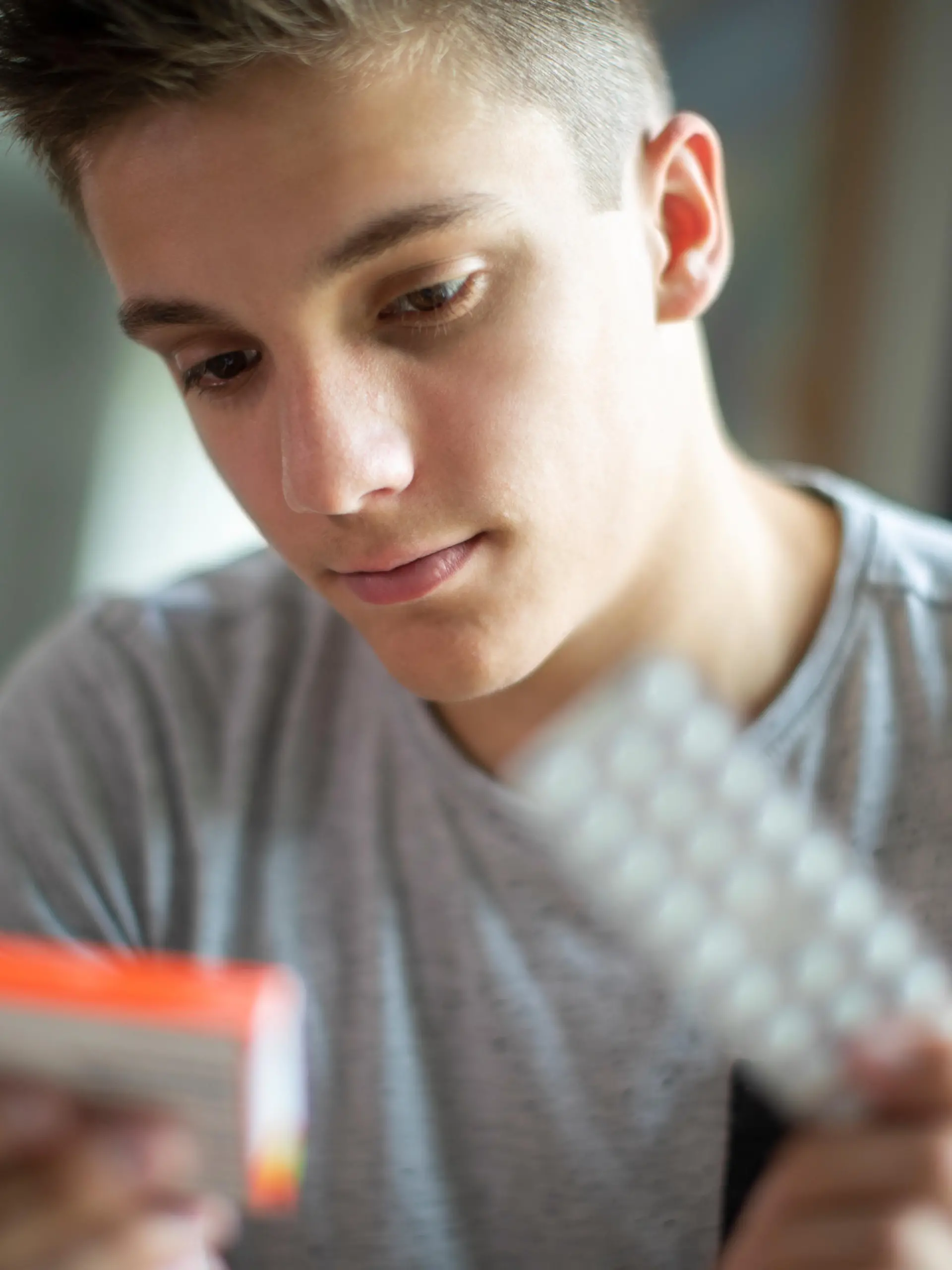 Teenage Boy With Mental Health Problems Taking Medication At Home