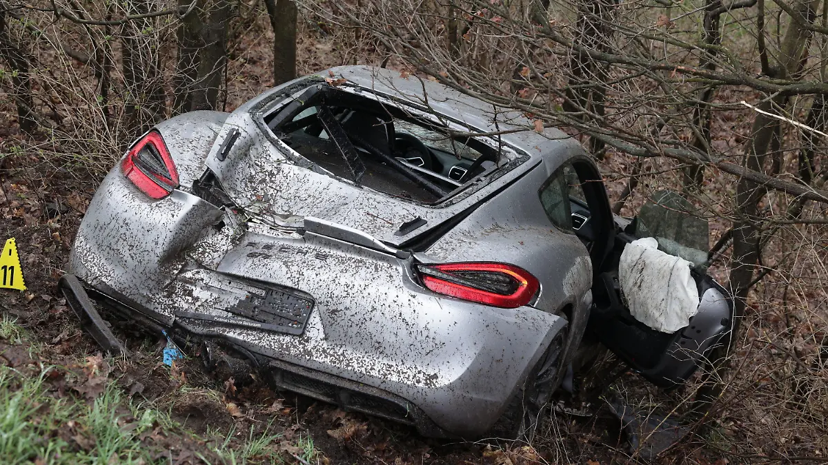 26.03.2023, Nordrhein-Westfalen, Emmerich: Ein demolierter Porsche liegt in der Böschung neben der A3 bei Emmerich. Vier Menschen sind bei kurz aufeinander folgenden Unfällen auf der A3 bei Emmerich am Niederrhein ums Leben gekommen - darunter auch ein Ersthelfer. Rettungshubschrauber, Notärzte und Krankenwagen waren den Angaben zufolge im Einsatz. Der Autobahnabschnitt Richtung Köln wurde voll gesperrt. Drei an den Unfällen beteiligte Fahrzeuge hatten niederländische Zulassungen. Foto: David Young/dpa +++ dpa-Bildfunk +++
