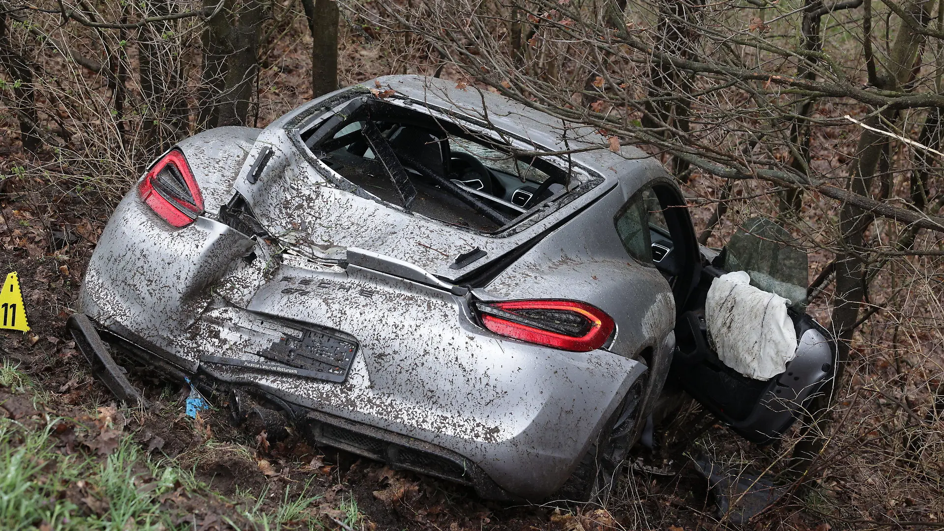 26.03.2023, Nordrhein-Westfalen, Emmerich: Ein demolierter Porsche liegt in der Böschung neben der A3 bei Emmerich. Vier Menschen sind bei kurz aufeinander folgenden Unfällen auf der A3 bei Emmerich am Niederrhein ums Leben gekommen - darunter auch ein Ersthelfer. Rettungshubschrauber, Notärzte und Krankenwagen waren den Angaben zufolge im Einsatz. Der Autobahnabschnitt Richtung Köln wurde voll gesperrt. Drei an den Unfällen beteiligte Fahrzeuge hatten niederländische Zulassungen. Foto: David Young/dpa +++ dpa-Bildfunk +++