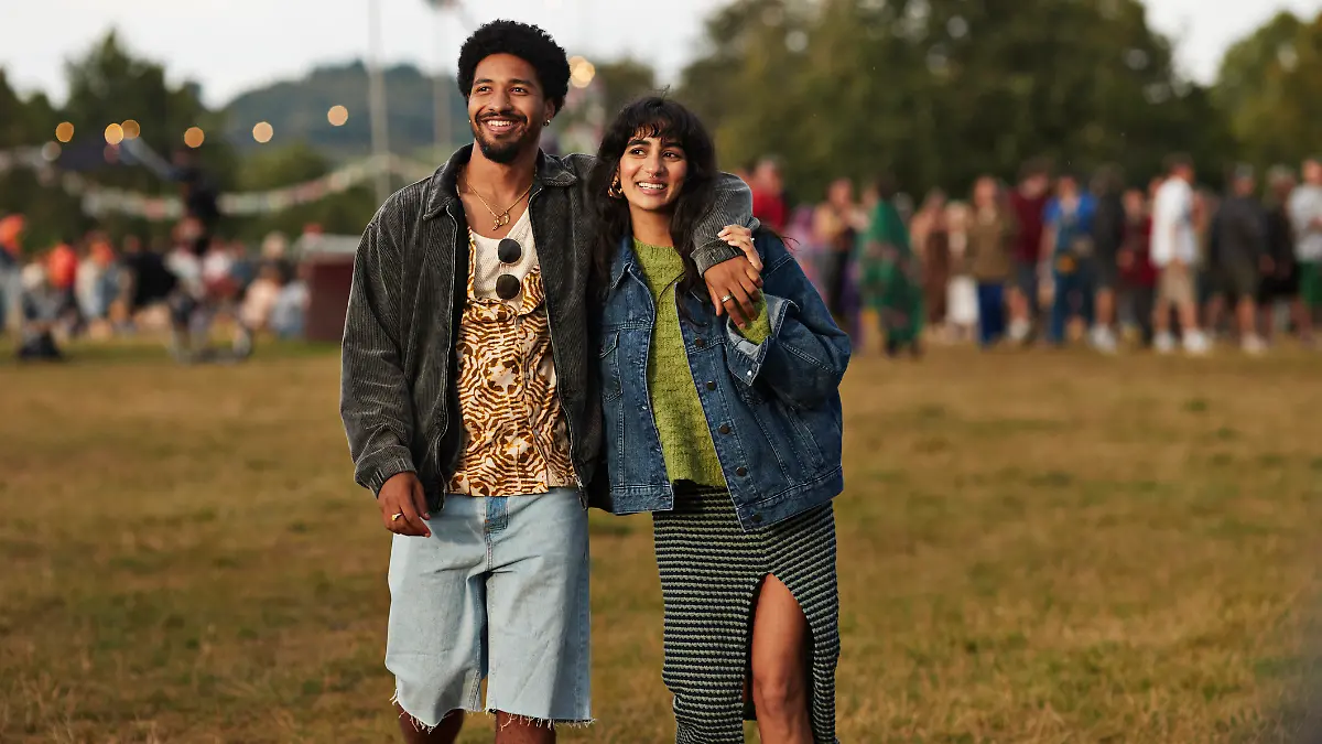 Pärchen in coolen Jeansjacken auf einem Festival im Sommer.