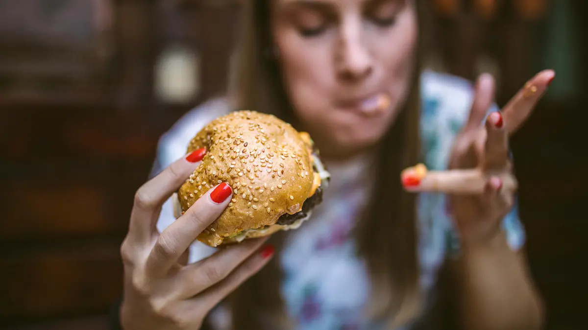 Junge Frau isst Burger