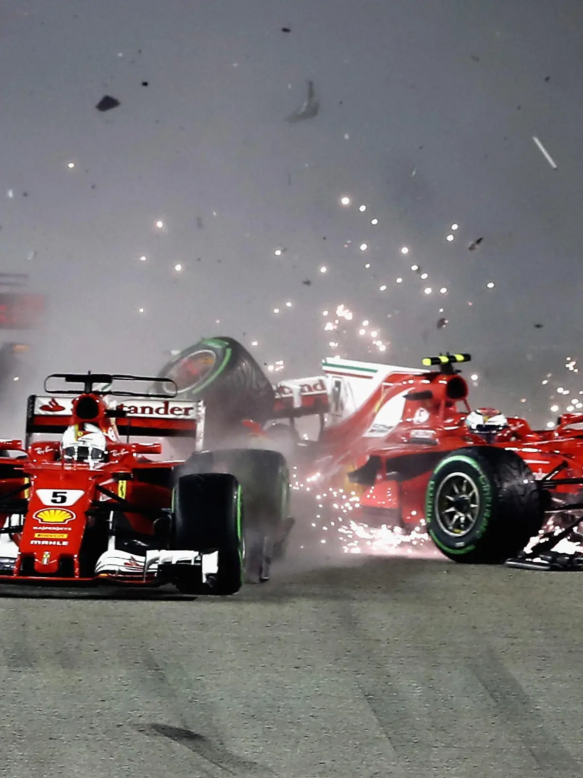SINGAPORE - SEPTEMBER 17:  Sebastian Vettel of Germany driving the (5) Scuderia Ferrari SF70H and Kimi Raikkonen of Finland driving the (7) Scuderia Ferrari SF70H collide at the start during the Formula One Grand Prix of Singapore at Marina Bay Street Circuit on September 17, 2017 in Singapore.  (Photo by Lars Baron/Getty Images)