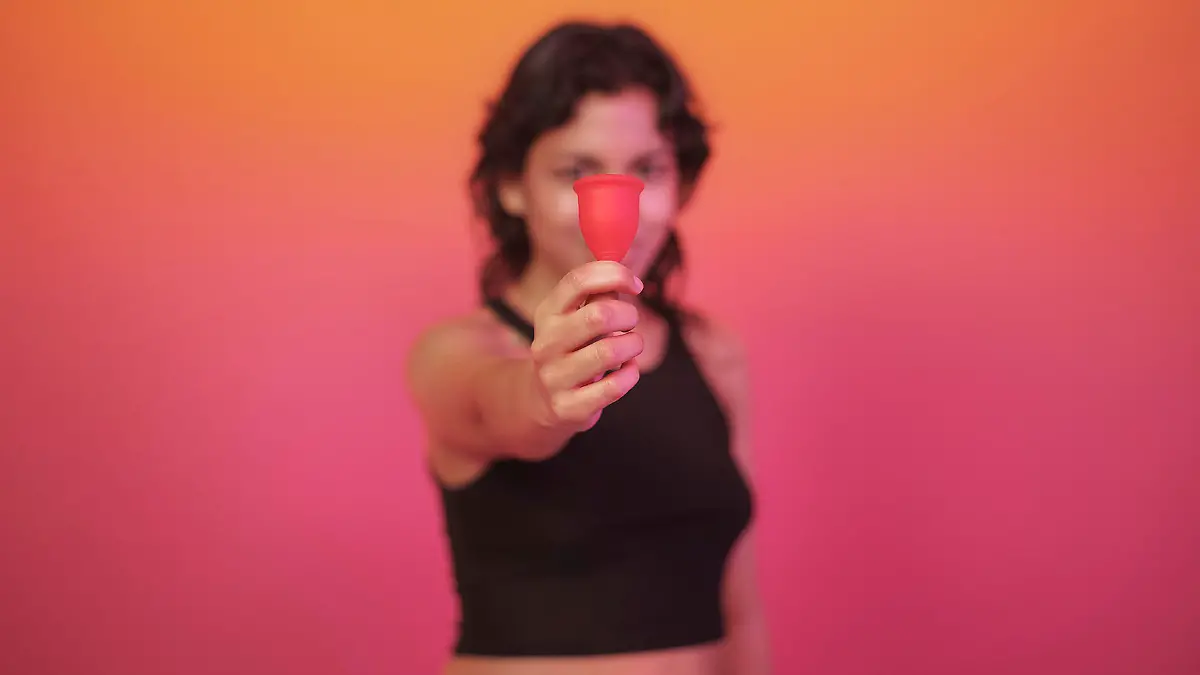 Lina Bembe hält eine Menstruationstasse