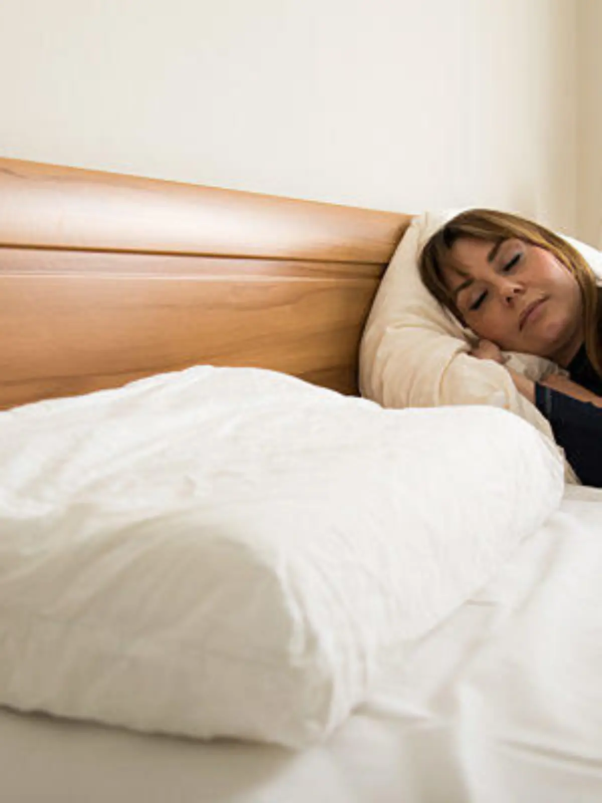 ILLUSTRATION - Eine junge Frau liegt am 21.05.2019 in einer Wohnung in Berlin in einem Bett und schlaeft (gestellte Szene). Foto: Christin Klose