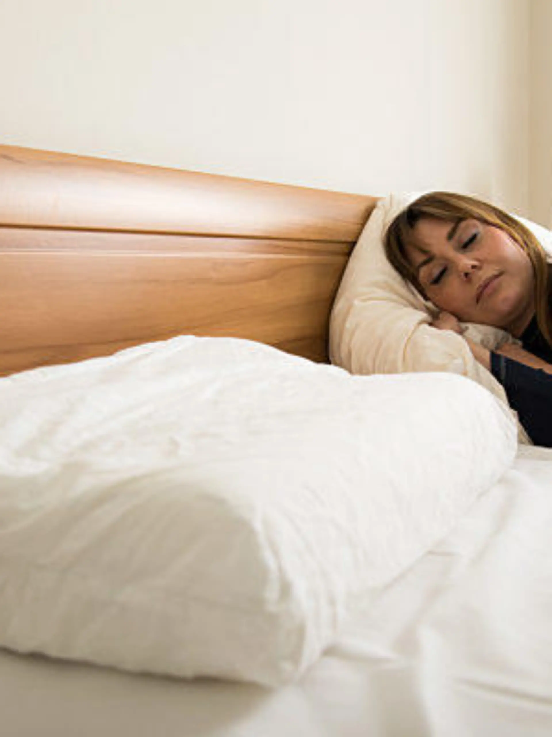 ILLUSTRATION - Eine junge Frau liegt am 21.05.2019 in einer Wohnung in Berlin in einem Bett und schlaeft (gestellte Szene). Foto: Christin Klose
