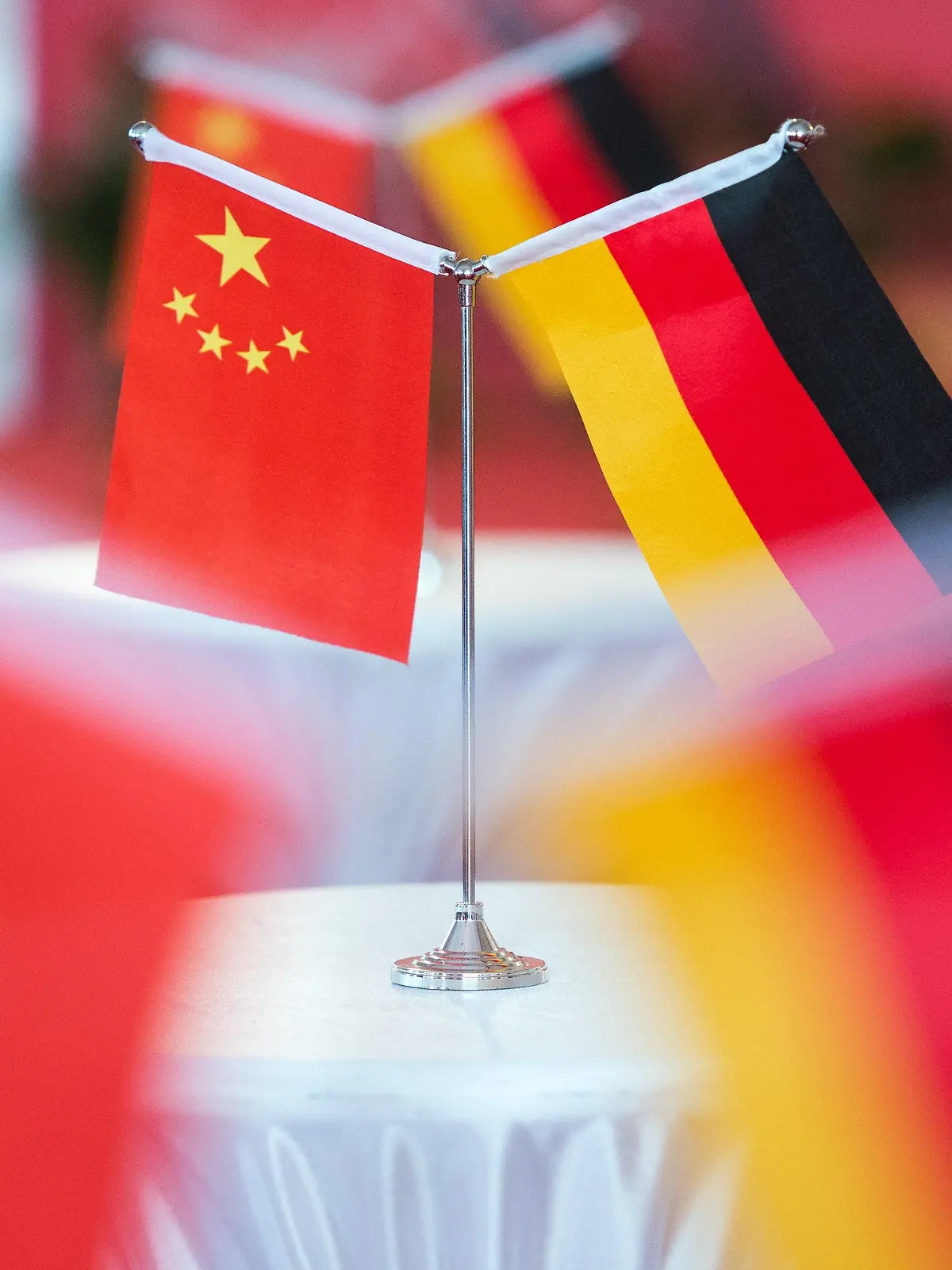 ARCHIV - 12.11.2014, China, Hefei: Chinesische und deutsche Flaggen stehen bei einem Empfang in Hefei. (zu dpa "BDI: Investitionsabkommen mit China muss noch dieses Jahr kommen") Foto: picture alliance / dpa +++ dpa-Bildfunk +++