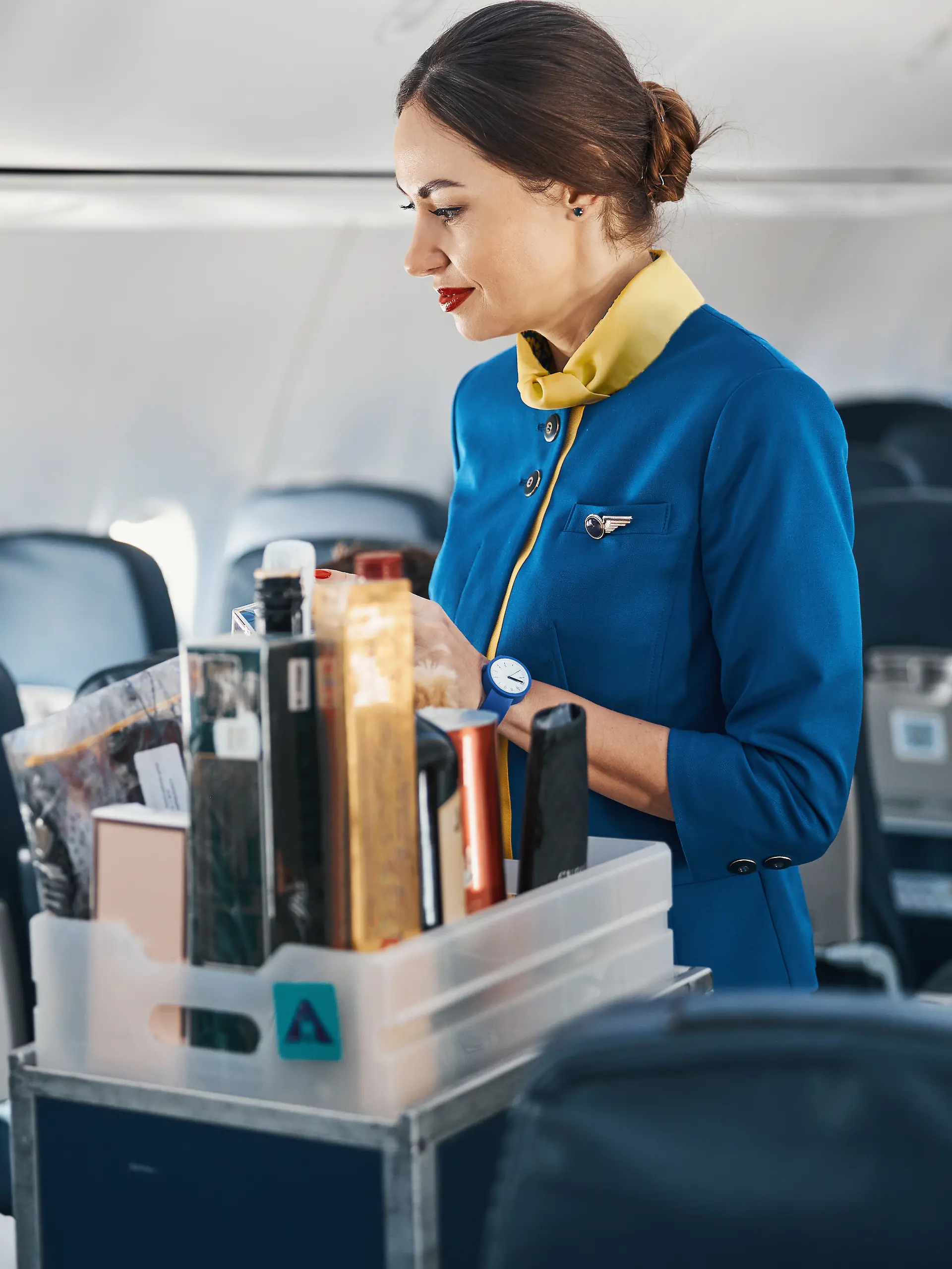 Flugbegleiterin verkauft Parfum im Flugzeug.