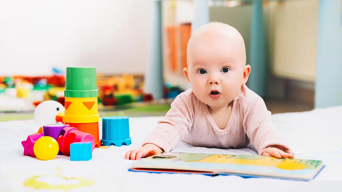 Baby mit Spielzeug und Buch
