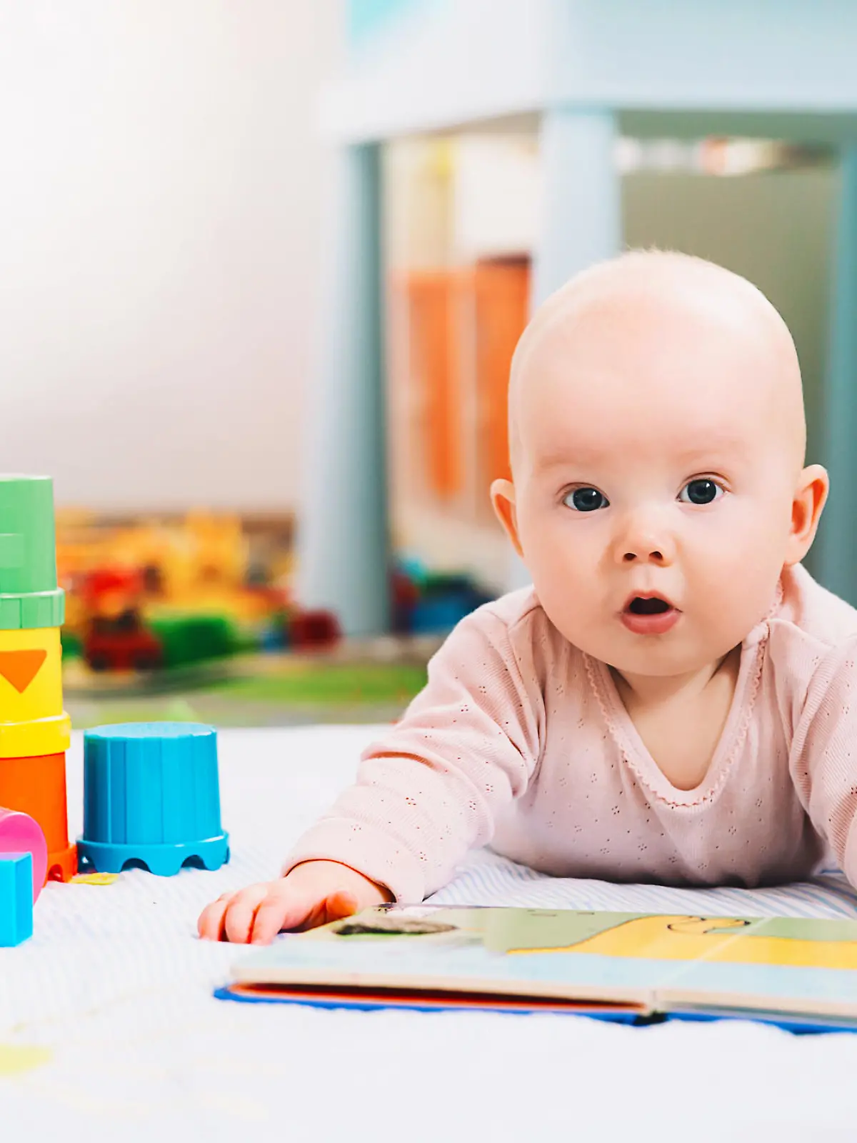 Baby mit Spielzeug und Buch