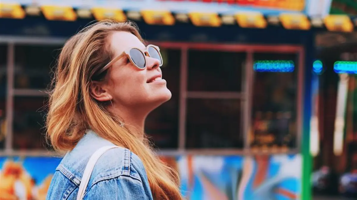 Frau trägt Jeansjacke auf einem Festival.