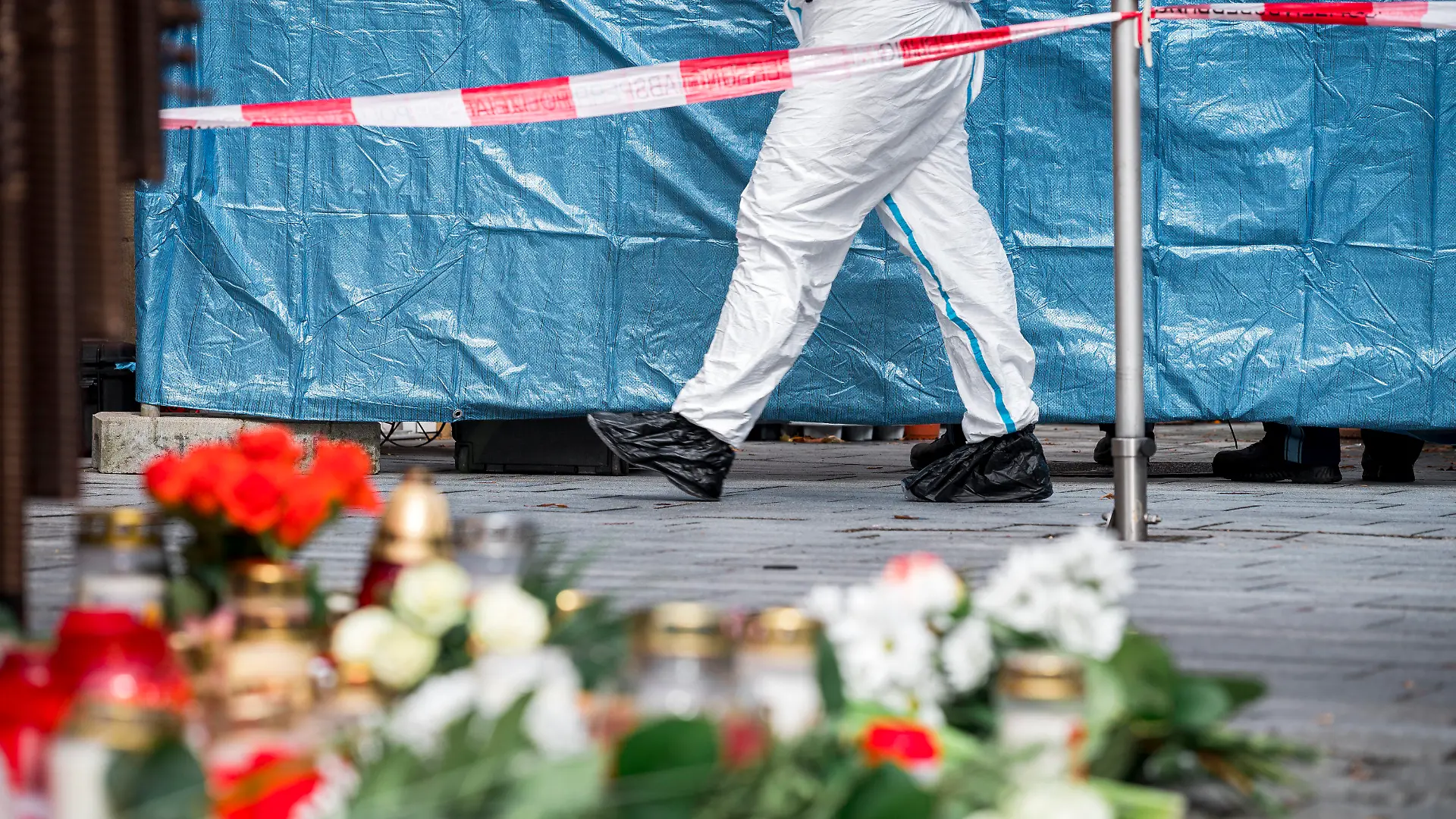 13.03.2023, Bayern, Lichtenfels: Ein Mitarbeiter der Spurensicherung geht in den abgesperrten Bereich vor dem Blumengeschäft, in dem am Freitagabend eine leblose Frau aufgefunden wurde. Spaziergänger hatten die tote 50-Jährige in dem Blumenladen in der Lichtenfelser Innenstadt entdeckt. Foto: Daniel Vogl/dpa +++ dpa-Bildfunk +++
