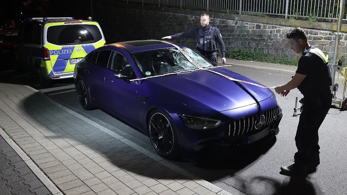 Ein beschädigter Mercedes AMG steht nach einem Unfall auf einer Straße