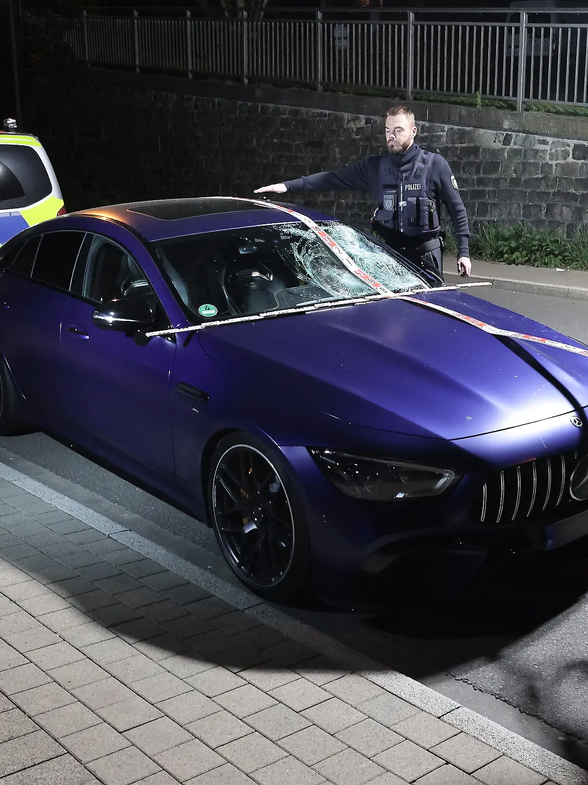 Ein beschädigter Mercedes AMG steht nach einem Unfall auf einer Straße