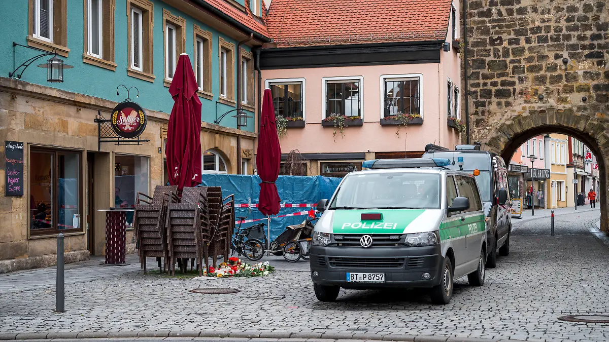 13.03.2023, Bayern, Lichtenfels: Einsatzwagen der Polizei und der Spurensicherung stehen vor dem Blumengeschäft, in dem am Freitagabend eine leblose Frau aufgefunden wurde. Spaziergänger hatten die tote 50-Jährige in dem Blumenladen in der Lichtenfelser Innenstadt entdeckt. Foto: Daniel Vogl/dpa +++ dpa-Bildfunk +++