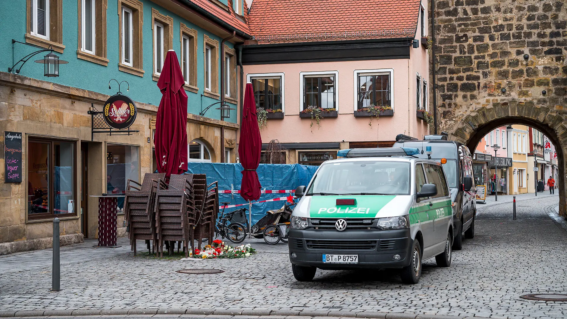 13.03.2023, Bayern, Lichtenfels: Einsatzwagen der Polizei und der Spurensicherung stehen vor dem Blumengeschäft, in dem am Freitagabend eine leblose Frau aufgefunden wurde. Spaziergänger hatten die tote 50-Jährige in dem Blumenladen in der Lichtenfelser Innenstadt entdeckt. Foto: Daniel Vogl/dpa +++ dpa-Bildfunk +++